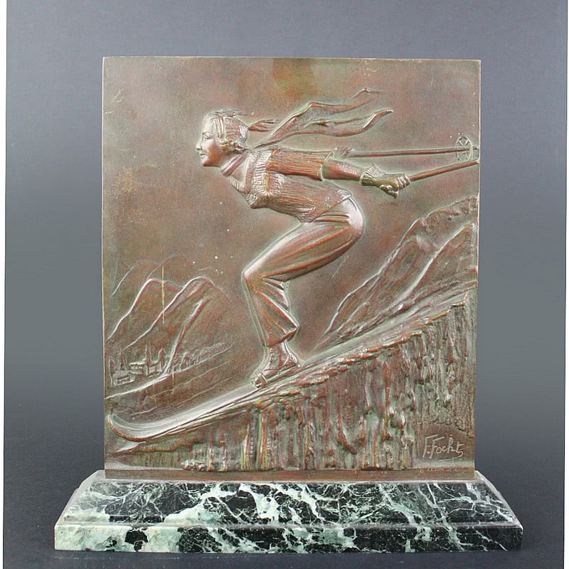  20th Century Decorative Arts |A rare Art Deco bronze sculptural plaque, circa 1930, Frederic Focht, France the patinated bronze featuring a dynamic downhill skier, mounted on a green marble base.